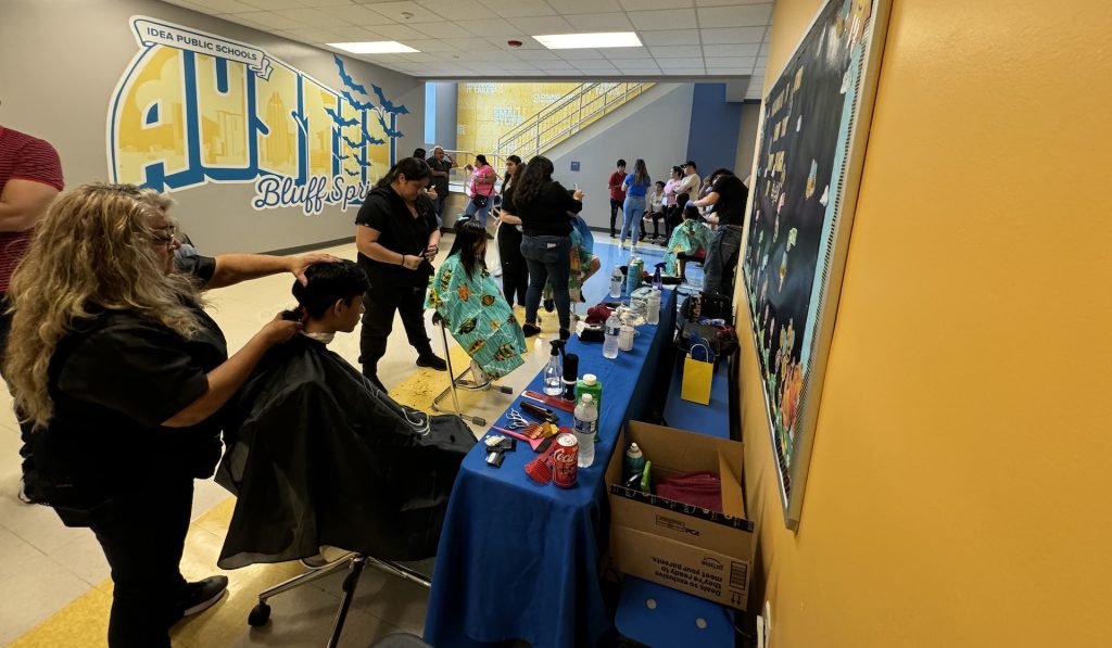 Multiple hairdressers at an Austin Back to School event cutting hair